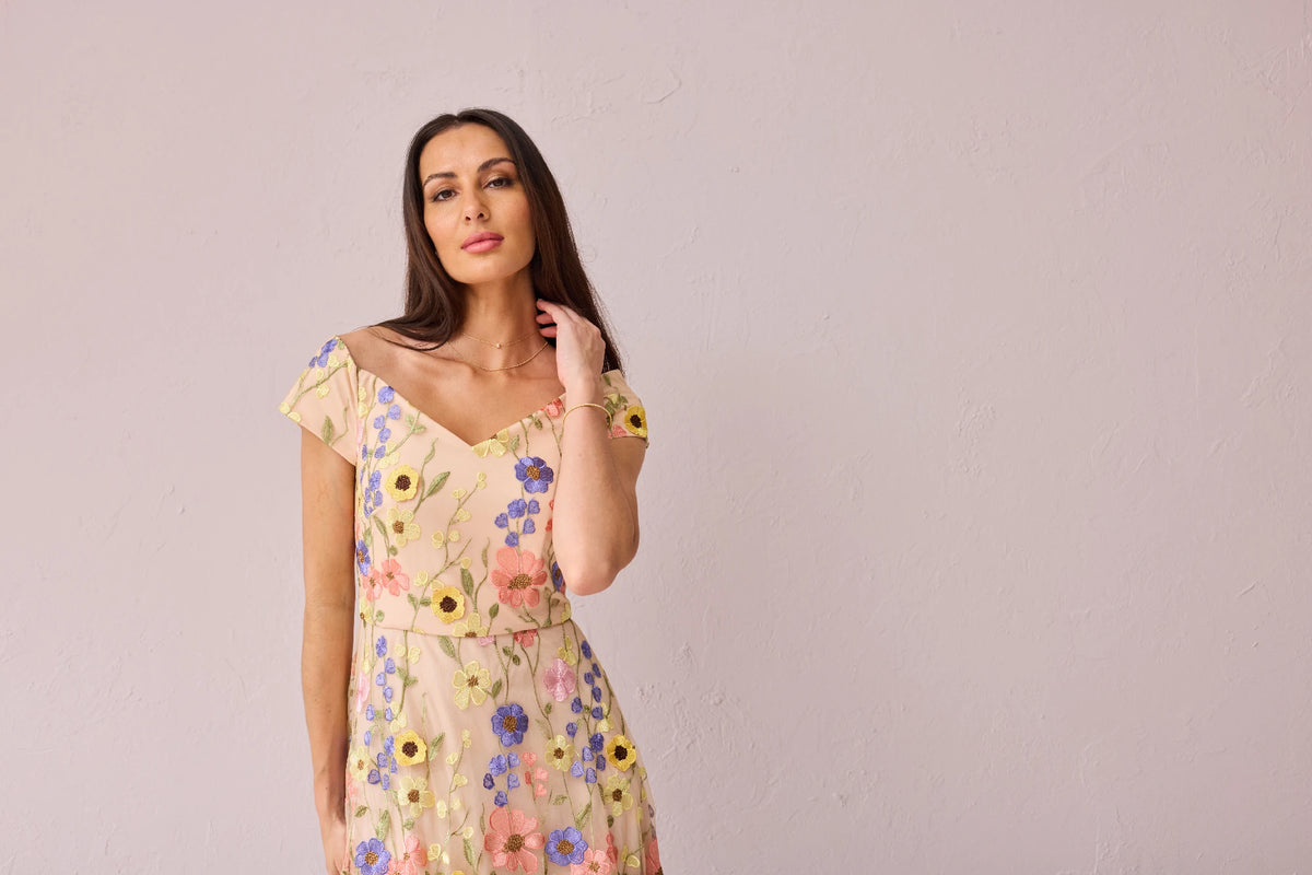 Woman wearing a floral dress against a plain background