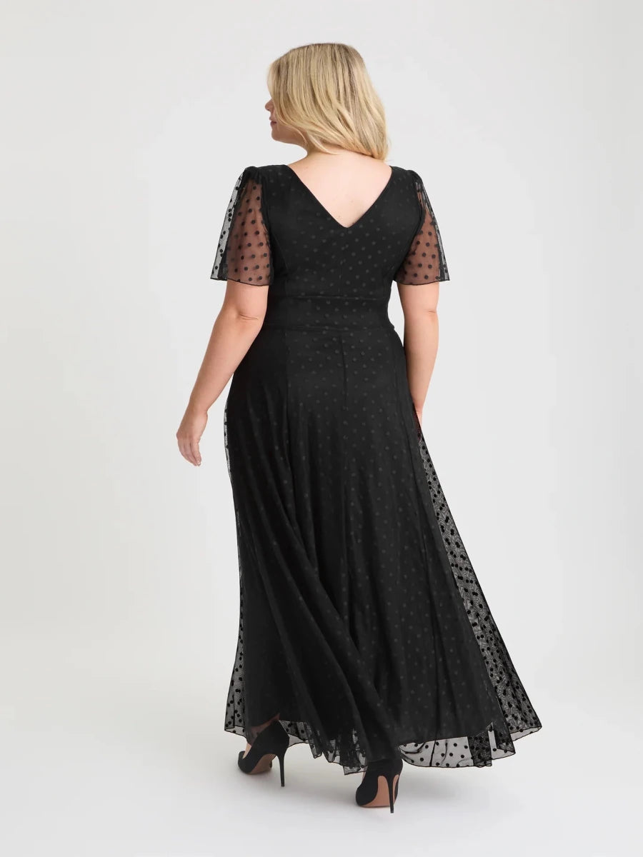 Back view of Scarlet &amp; Jo Isabelle black maxi dress showing the V-shaped back neckline, sheer spot sleeves and flowing skirt.