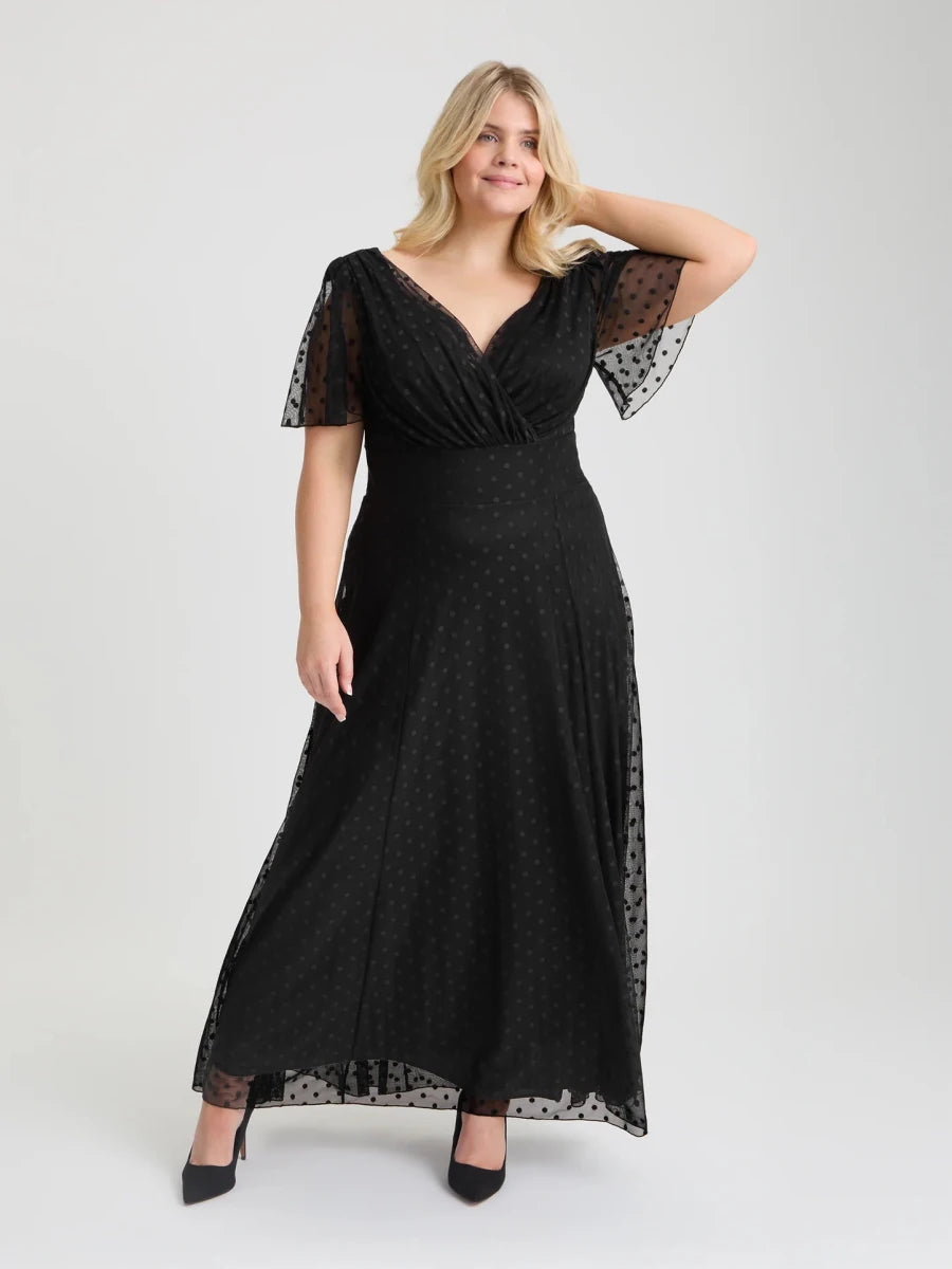 Isabelle black dobby spot maxi dress by Scarlet &amp; Jo featuring a wrap-style V-neckline, sheer angel sleeves and flowing skirt.